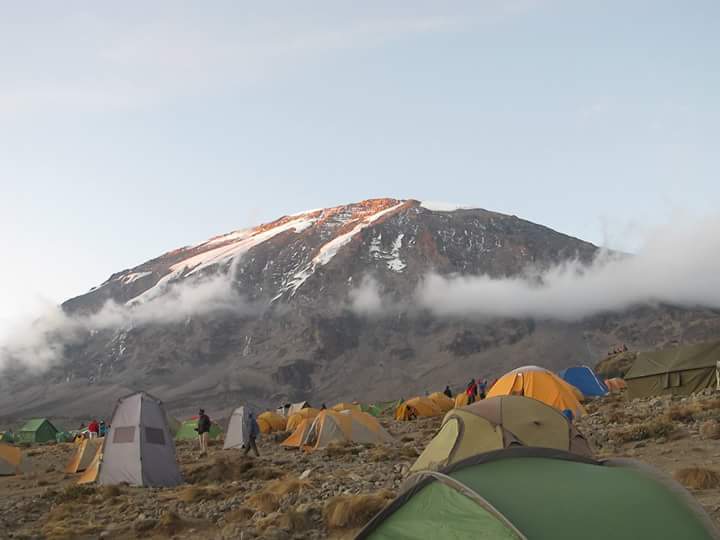 multiple tents set-up surrounding a mountain