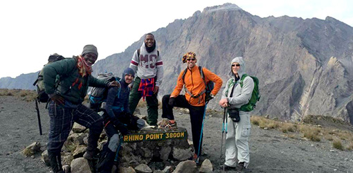 five trekkers posing in Rhino Point 3800M signage