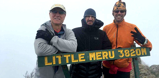 three male individuals posing in front of Little Meru 3820M signage